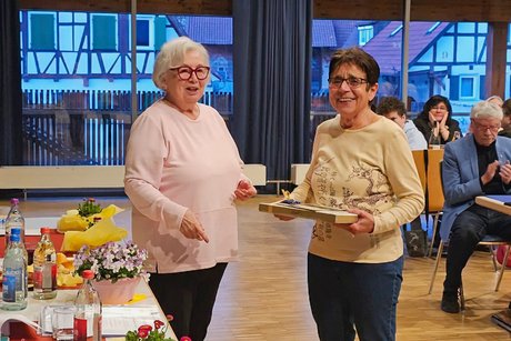 Hauptversammlung VdK OV Echterdingen 2026 Zwei Damen lächeln in die Kamera, die rechte hält ein großes Geschenk in den Händen