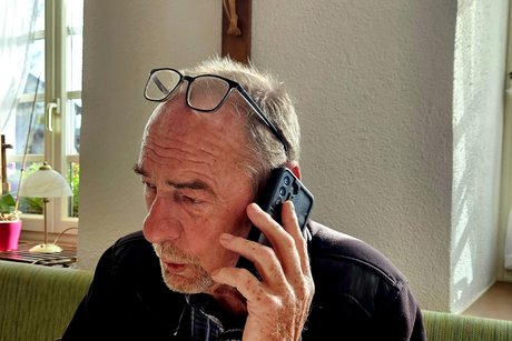 Unser ehemaliger Vorsitzender telefoniert direkt unter dem Jesuskreuz der Wirtschaft.