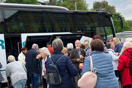Menschengruppe vor einem Reisebus.
