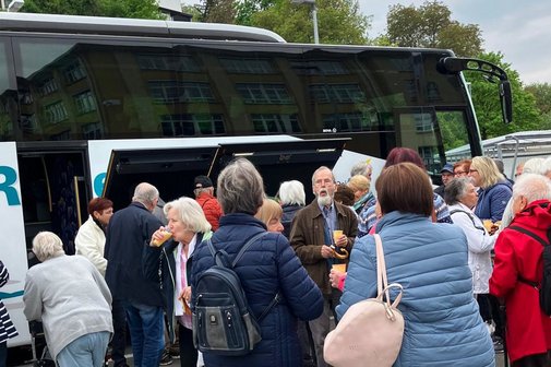Menschengruppe vor einem Reisebus.