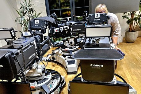 Ein Mitglied schaut durch eine gro&szlig;e Fernsehkamera als w&uuml;rde sie uns filmen.