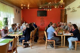 2 Tischtafeln mit Gästen bei Kaffee & Kuchen