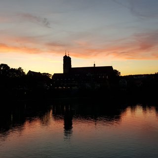 Stimmungsbild: Das Münster von Bad Säckingen im Abendrot spiegelt sich im Rhein