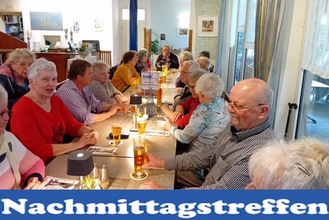 Bild zeig Leute an den Tischen sitzend
