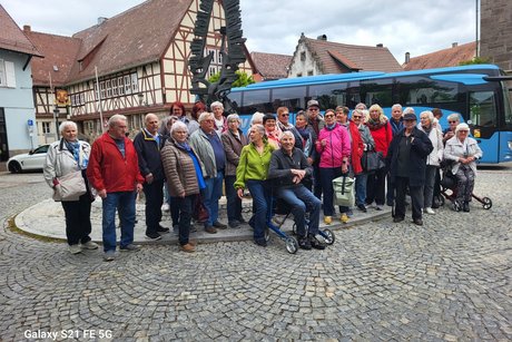 Eine Gruppe von Menschen steht vor einem Reisebus