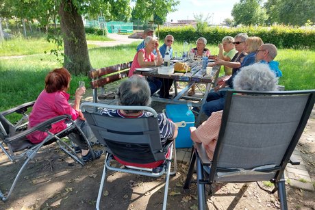 Boulegruppe um einen Tisch versammelt, es wird etwas Erfrischendes getrunken