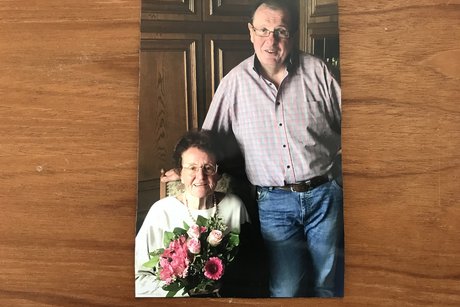 Links sitzt die Jubilarin Ruth Schmidt mit Blumenstrauß in der Hand. Rechts neben ihr steht der Kreis- und Ortsverbandsvorsitzende Frank Burkhardt.