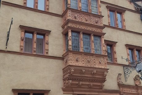 Ein repr&auml;sentatives Stadthaus in Colmar mit vorgebauten verglasten Balkonen und verschn&ouml;rkelten Bauteilen