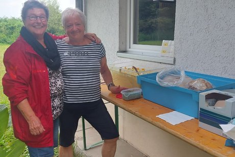 Zwei Frauen geben Kartoffelsalat aus