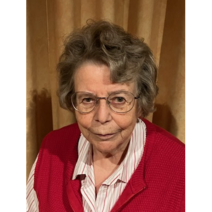 &Auml;ltere Dame mit grauen Haaren und Brille tr&auml;gt rote &auml;rmellose Weste und Bluse.