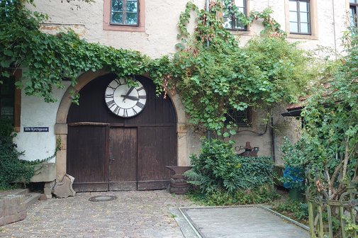 Winzermuseum Rauenberg altes Scheunentor mit großen Uhrenzifferblatt umrankt von Efeu im Hof des Winzermuseums Rauenbergg