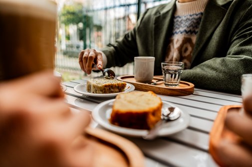 Sozialverband VdK Gemeinschaft Ehrenamt Kaffee Kuchen Nahaufnahme einer Frau, die mit Freunden Kuchen isst und Kaffee trinkt.