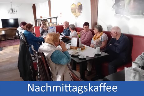 Bild zeigt Personen beim trinken und essen an Tischen im Freien