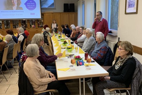viele Personen sitzen an den Tischen