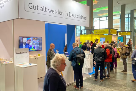 Deutscher Seniorentag 2025 - Informationsstand auf einer Messe mit Menschen darum herum