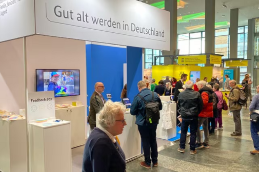 Deutscher Seniorentag 2025 - Informationsstand auf einer Messe mit Menschen darum herum