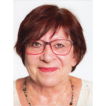 Frau mit rötlich gefärbten Haaren, roter Brille und rot geschminkten Lippen.