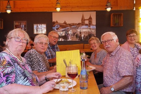 ESTiVAL Eine Gruppe von Frauen und Herren sitzt an einem Biertisch und lächelt freundlich in die Kamera.