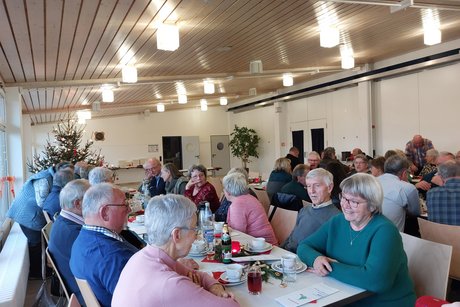 Teilnehmer der Weihnachtsfeier im festlich geschmückten Foyer der Schloßbühlhalle