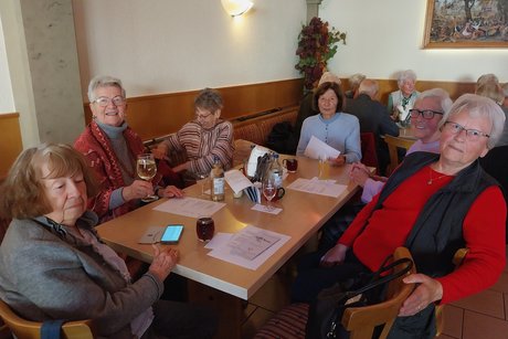 Besen Neipperg Sechs ältere Frauen sitzen an einem Tisch, auf dem Weingläser stehen, und lächeln in die Kamera.