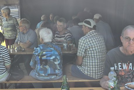 Mehrere Mitglieder im schattigen Zelt