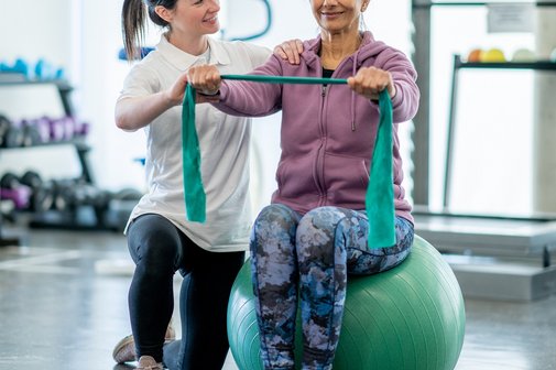 Frau auf Sitzball bei der Physiotherapie