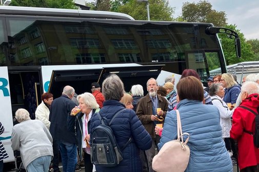 Menschengruppe vor einem Reisebus.