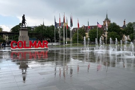 Platz in Colmar mit Schriftzug, Bartholdi-Statue und Springbrunnen