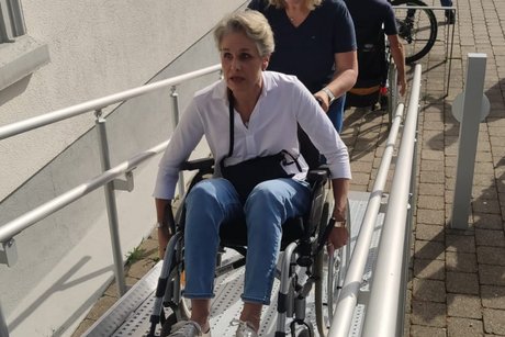 Auf der Rampe beim Rathaus im Rollstuhl hoch geschoben wird Todtnaubergs Ortsvorsteherin Franziska Brunner von Stadträtin Irene Breuer aus Todtnauberg