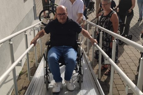 Schlechtnaus Ortsvorsteher/Stadtrat Sven Behringer im Rollstuhl bekommt manuelle Schiebehilfe von Bürgermeister Oliver Fiedel.