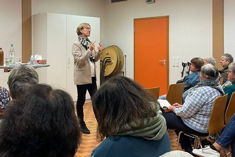 Referentin Regina Rüttnauer steht gestikulierend vor den sitzenden Zuhörenden im Pfarrsaal