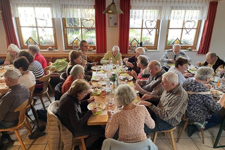 Personen sitzen am Tisch und essen