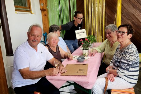 Ein besonders sch&ouml;n geschm&uuml;ckter Tisch im &uuml;berdachten Grillfestbereich besetzt mit Ehreng&auml;sten.