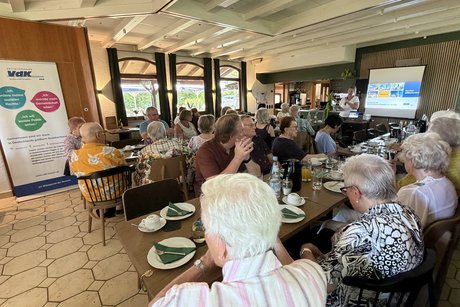 Besucherinnen und Besucher des Sommerfests sitzen an Tischen im Restaurant Hasenheim