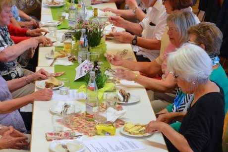 Tisch mit mehreren Personen, die zu Abend essen.