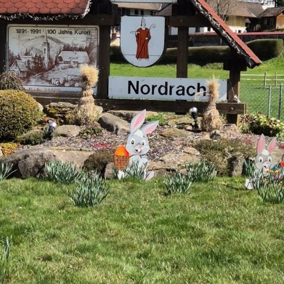 Zeigt Ortsschild von Nordrach mit den Figuren von Nordis Rätselweg