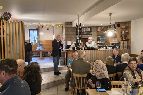 G&auml;ste sitzen an Tischen einer Gastwirtschaft