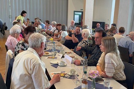 Vier Menschen an einem Tisch, die sich angeregt und intensiv miteinander unterhalten.