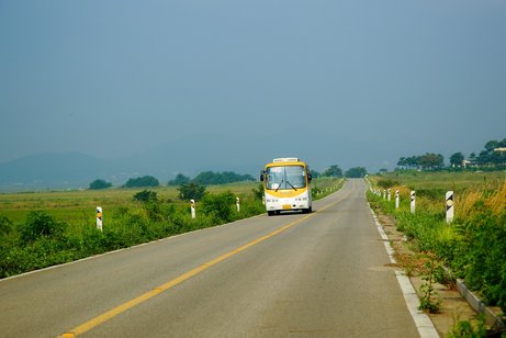 Reisebus auf der Straße inmitten grüner Landschaft