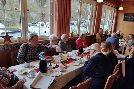 Weihnachtsfeier Bild zeigt die Anwesenden bei Kaffee und Kuchen