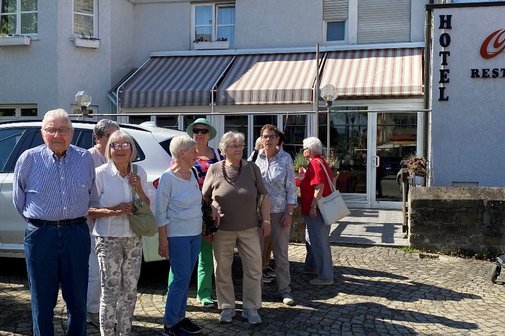 Frühjahrsausflug Gruppe von sieben älteren Personen posiert vor einem Hotelgebäude.