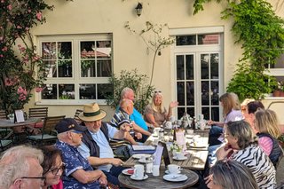 Bild zeigt die Gruppe im Freien unter einem Baum sitzend