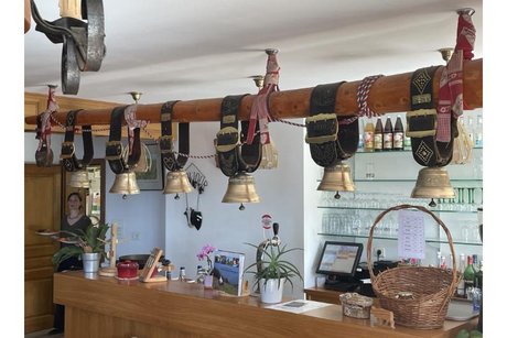 Kuhglocken über der Theke der Ferme Auberge Hahnenbrunnen Kuhglocken