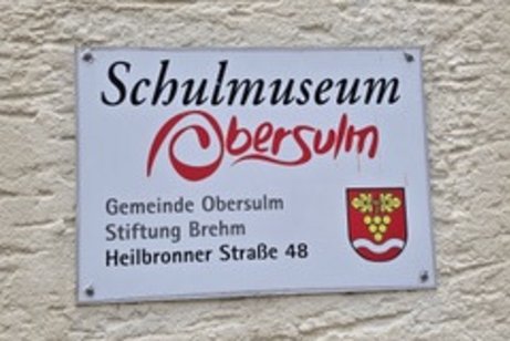 Schild am Schulmuseum Obersulm mit Adresse Heilbronner Stra&szlig;e 48 an einer Hauswand.