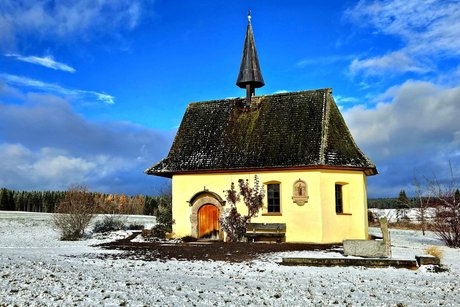 fröhliche Weihnachten Eine kleine Kapelle im Schnee bei strahlendem Sonnenschein.