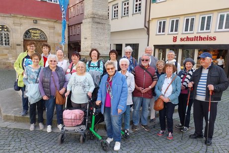 Gruppenbild mit 19 älteren Menschen vor dem Adlerbrunnen in Esslingen.