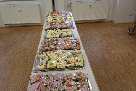 Ein Tisch mit Platten mit belegten Br&ouml;tchen zur St&auml;rkung der Mitglieder steht bereit