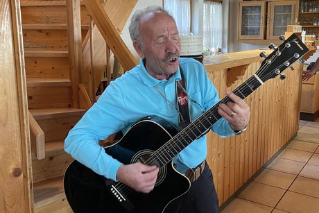 Mario spielt auf der Gitarre und singt