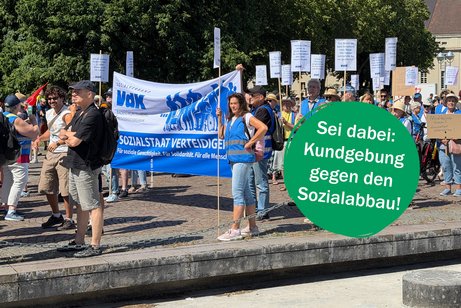 Eine Menschenmenge auf einem Bahnsteig mit Bannern und Schildern des VdK zur Demonstration