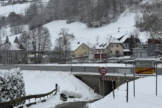 Zu sehen der steilere als maximal vorgeschrieben 6 Prozent laut DIN geteerte, schadhafte Weg zur Unterführung, Schnee liegt rechts und links